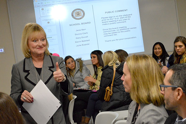 Superintendent Beth Niedermeyer circles the room before the school board meeting conversing among the audience. 