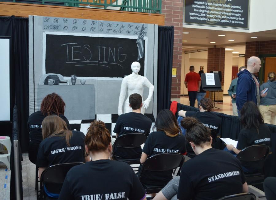 Students in the art department perform in the This is YOUR Voice installation. Student artists worked on the plaster person for 2 months and the background for one month.