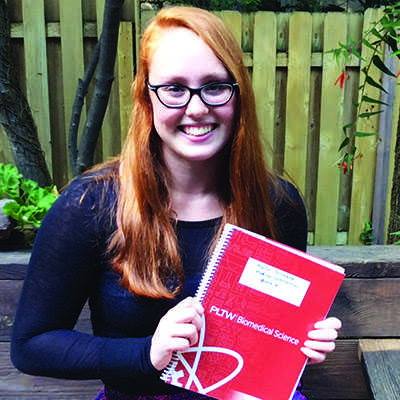 Kate Holtkamp holds her biomedical science notebook. Holtkamp has applied to Brown and Dartmouth University.