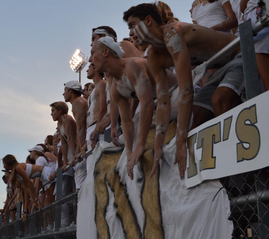 Senior+student+section+leaders+cheer+on+the+football+team+by+rattling+the+fence+at+the+opening+game+of+the+season.