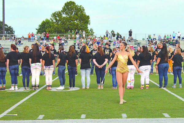 Ashley Britton, Noblesville High School junior, prepares to twirl her	baton. Britton performed during the homecoming football game.
