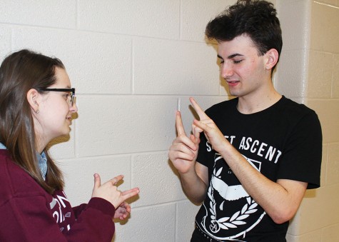 Sophomore Alec Lefors teaches sophomore Madalyn Judah how to sign 'I love you'. The two have been good friends since the end of freshman year. 