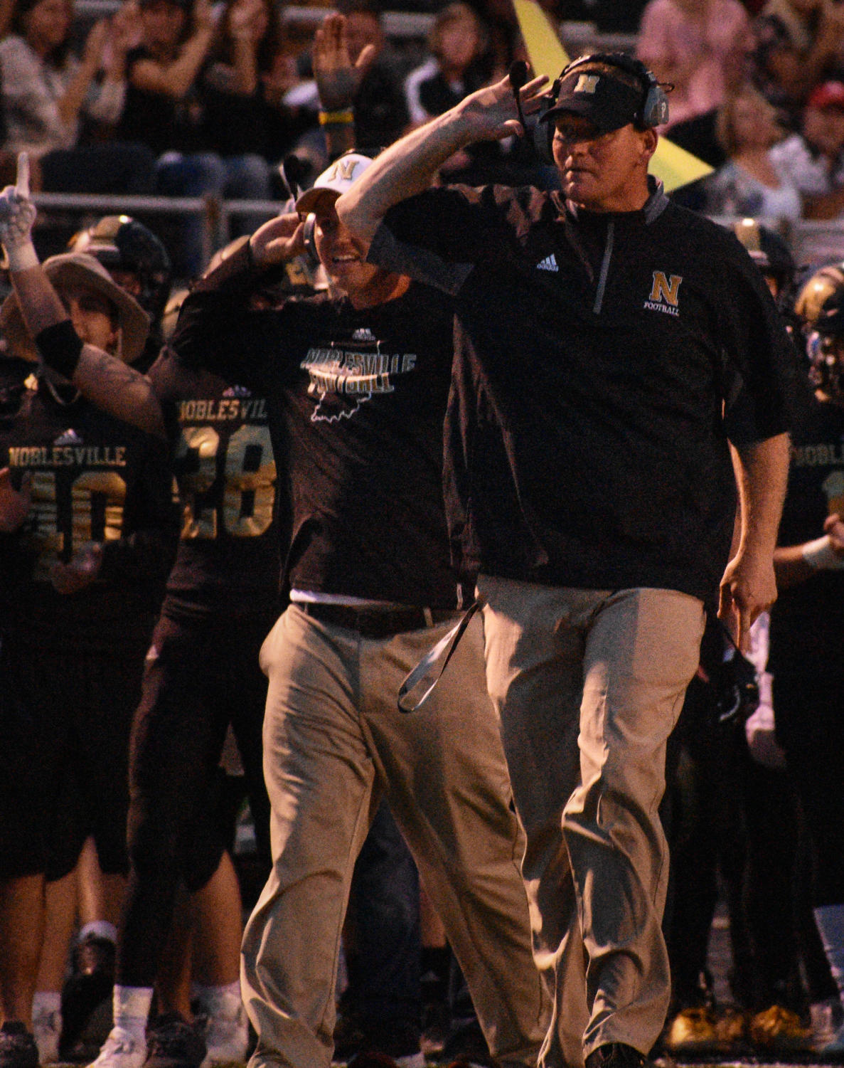 Coach Jason Simmons provides support on the sidelines during the NHS Pink Out game in October of 2017.
