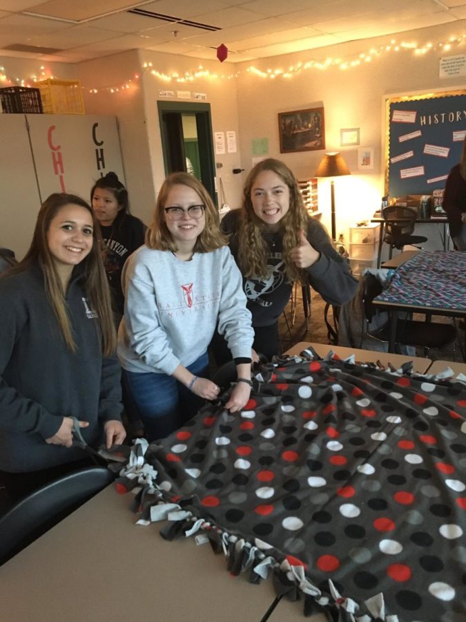 Seniors Haley Gunderson, Katie Janosky, and Shelby Tyler pose with their completed blanket.