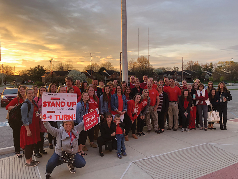 A group of NHS forum members gather in front of the school to show their support for #RedforED. “Our team has been working very hard with the district to come to an agreement that corrects the teacher pay issues here in Noblesville,” teacher Amanda Giordano said. 