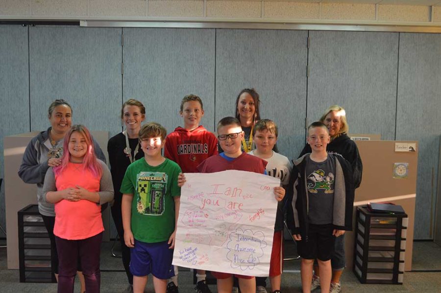 Griffins class holds the poster for their friend Ian. The poster explains all the good things they think about him. 