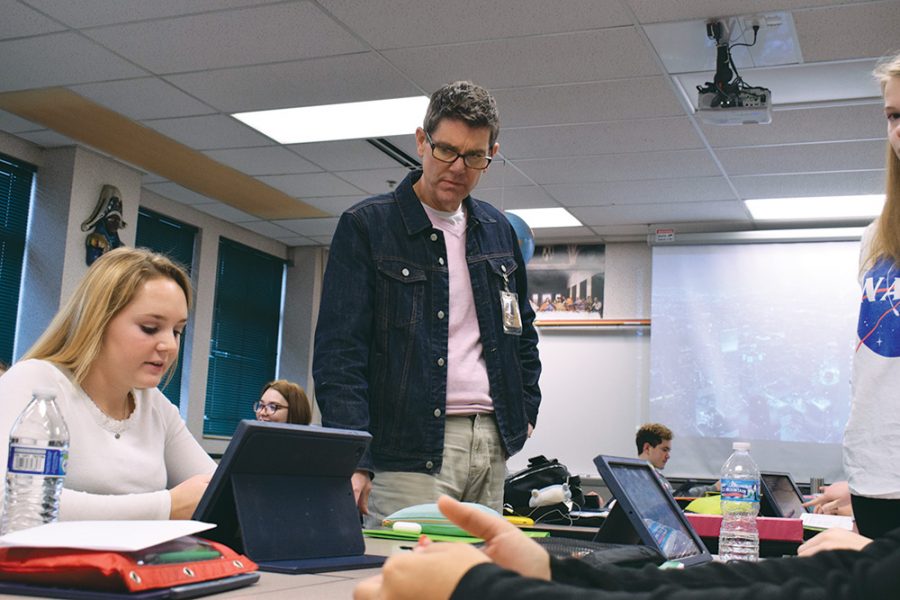 Explorations in Social Justice teacher Stanley Abell assists one of his students.