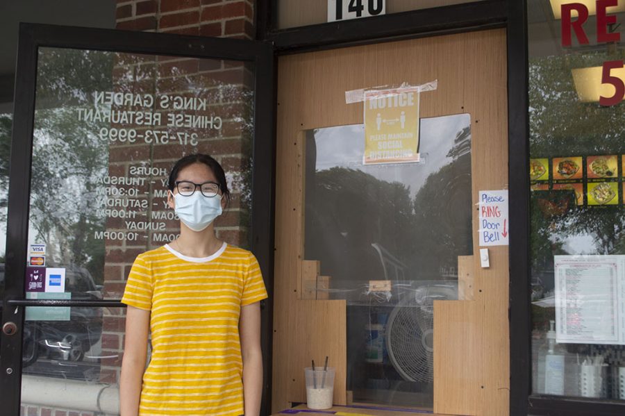 Nicole Liu stands in front of Kings Garden. The door of the takeout restaurant has been altered to adhere to COVID precautions.