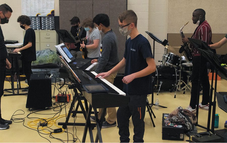 Marshall Axsom (middle) plays the piano during an after school practice. He is a member of the show choir band and the NHS Singers.