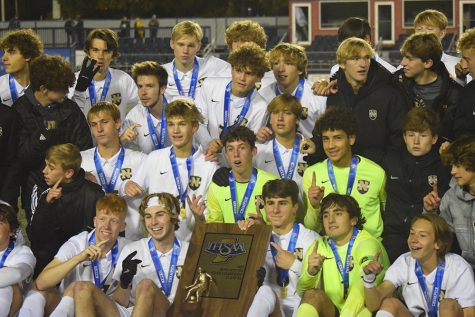The Noblesville Millers boys soccer team poses with their championship trophy. They defeated Carmel High School 3-1 Saturday night to become IHSAA state champions.