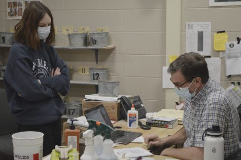Smith pictured speaking with one of his ceramics students. He assist many of them through design, building, and the final product.