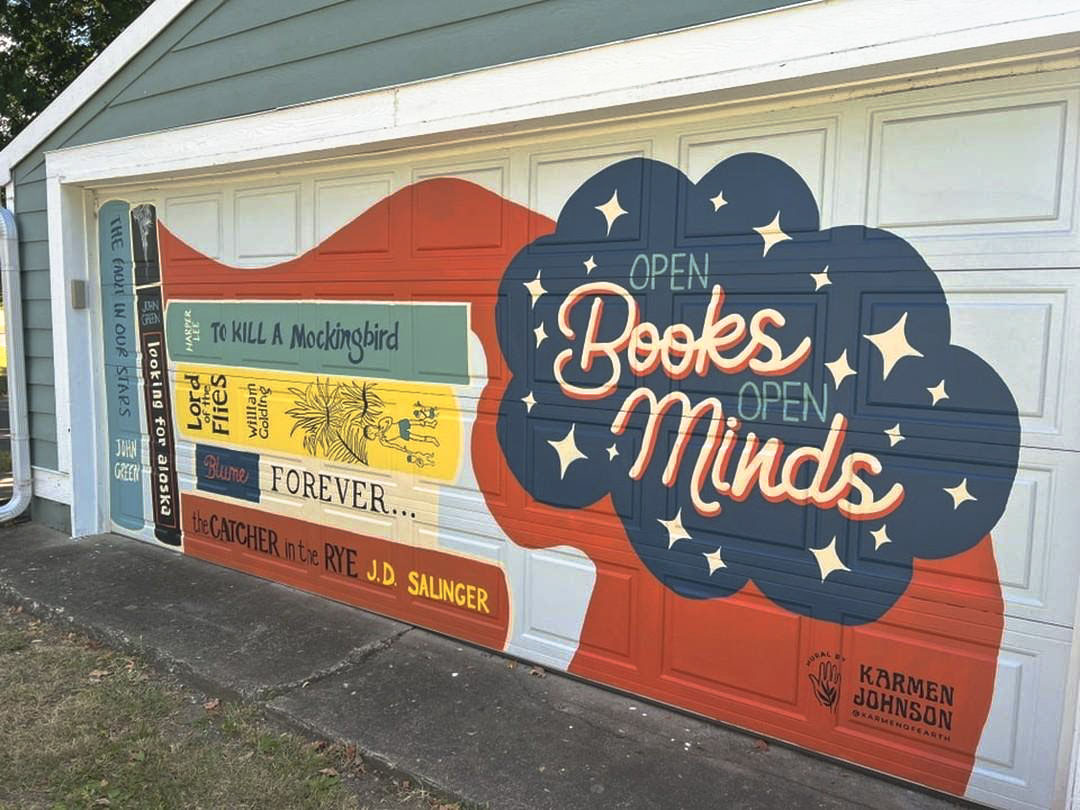 Hamilton East Public Library Board member Michelle Payne commissioned the mural on her garage with artist Karmen Johnson. The work represents Paynes beliefs about providing teens with access to books.