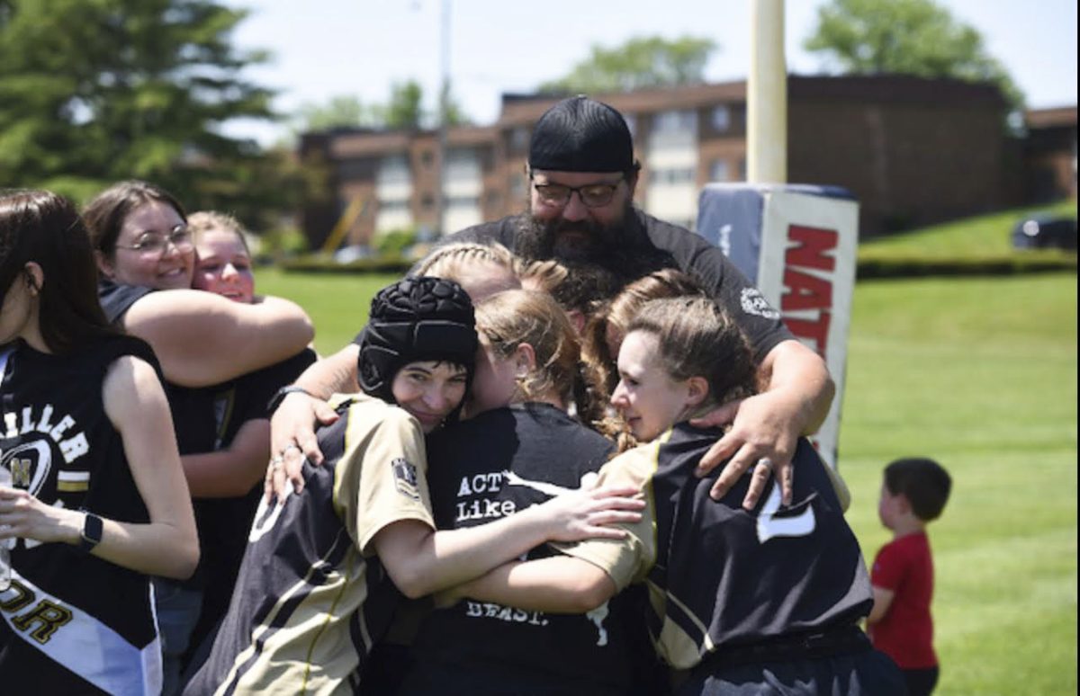 The+rugby+team+celebrates+a+victory+with+a+hug+from+former+coach+Justin+Henson.+According+to+the+team%2C+Henson+always+made+their+games+meaningful%2C+whether+they+left+with+a+win+or+a+loss.