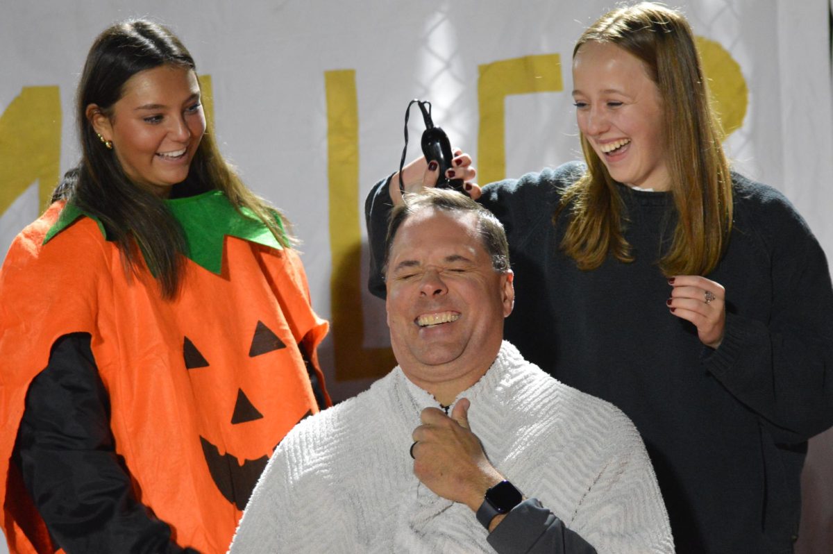 NHS Senior Olivia McCaffery shaves Dr McCafferys head during halftime