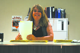 Shuler smiles as she files paperwork for the school dance. Each year, the school gets many students who out the forms for their homecoming dates.